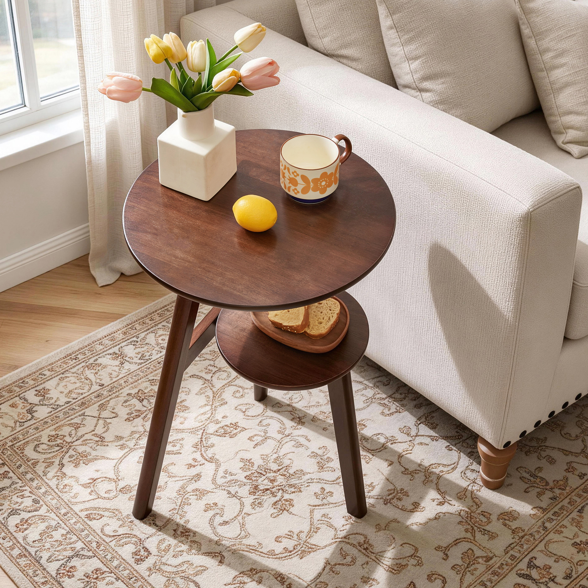 Close-up of tulips in a vase on top of the walnut 2-tier round side table next to a sofa