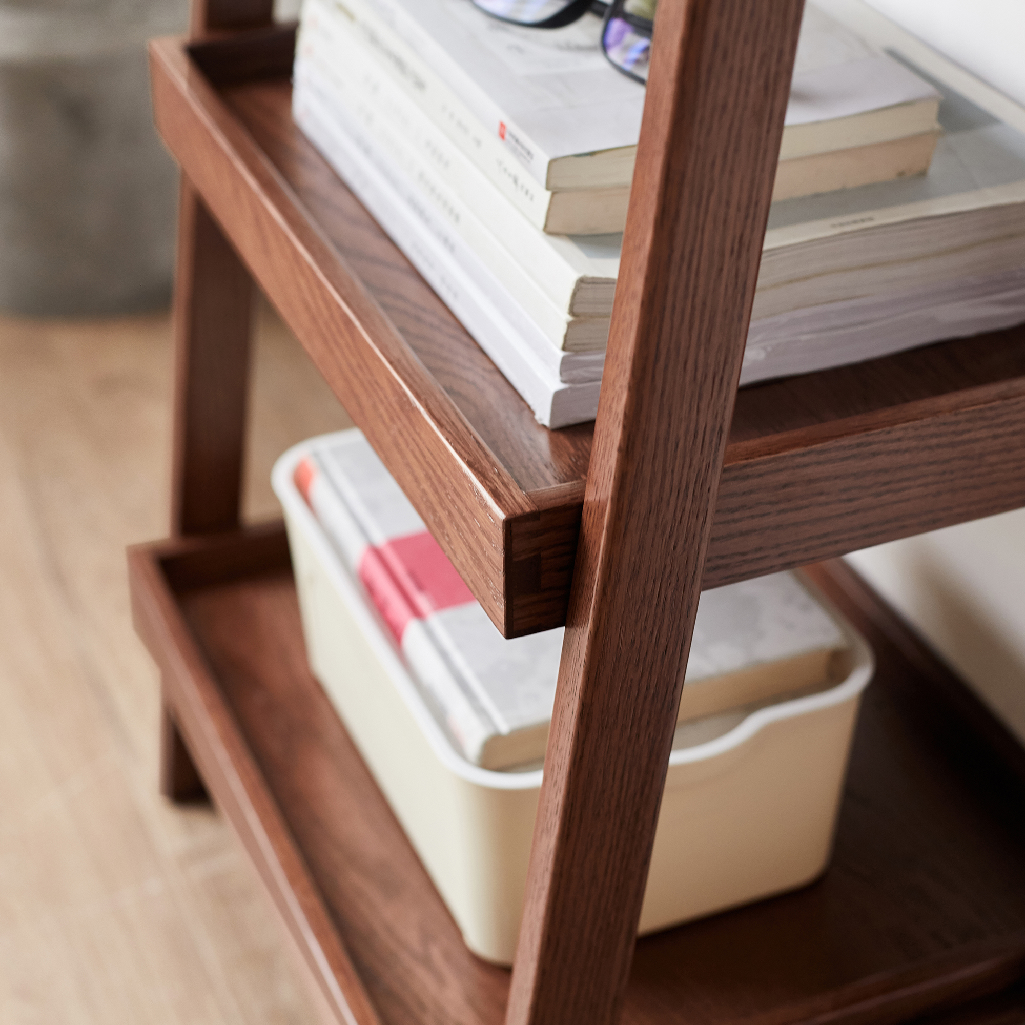 Walnut finish ladder shelf detail with books on the middle tier