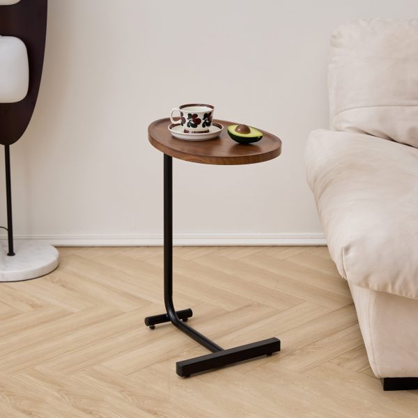 Slim brown C-shaped sofa table with wood-grain top beside a light sofa on wood flooring