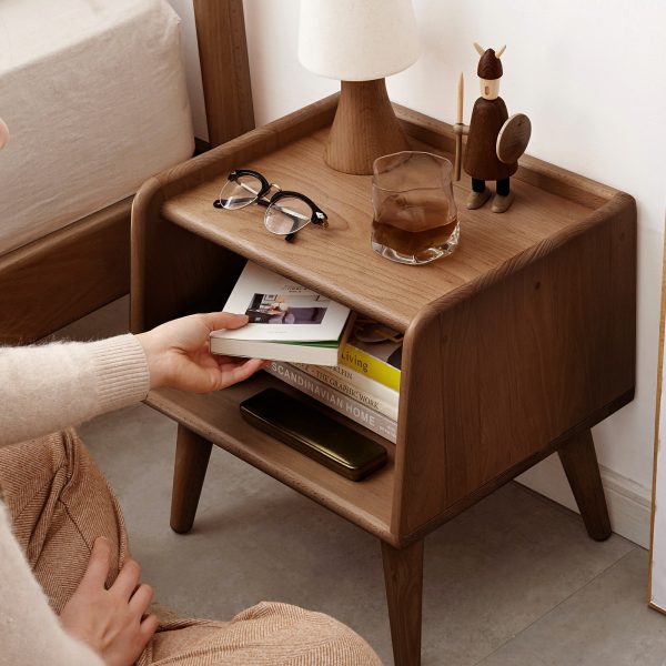 Open storage compartment of the solid walnut nightstand with cable management hole